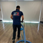 Man performing office cleaning services at a small business | Featured Image for the Office Cleaning Services Page of QCS Cleaning.